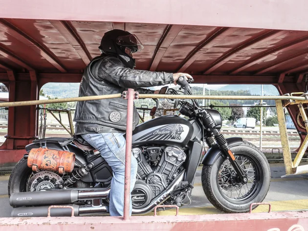 Motorradfahrer mit schwarzem Helm auf Indian-Motorrad auf Bahnrampe