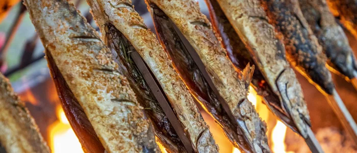 Grilled fish on skewers over open flame