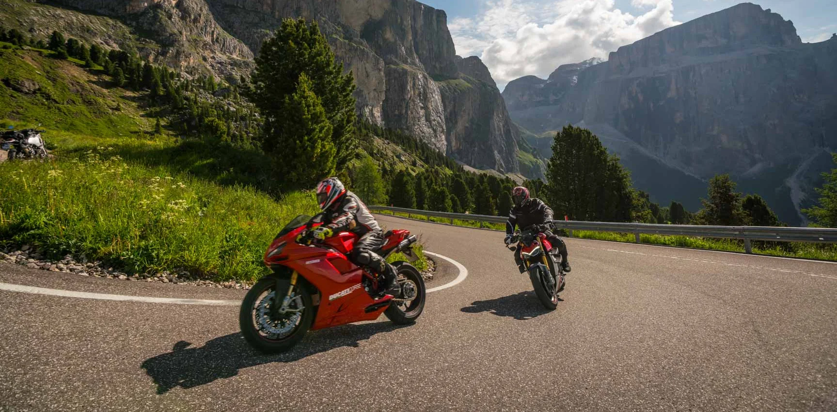 Italien © Moppetfoto.de Zwei Motorradfahrer fahren durch kurvige Bergstraße bei sonnigem Wetter