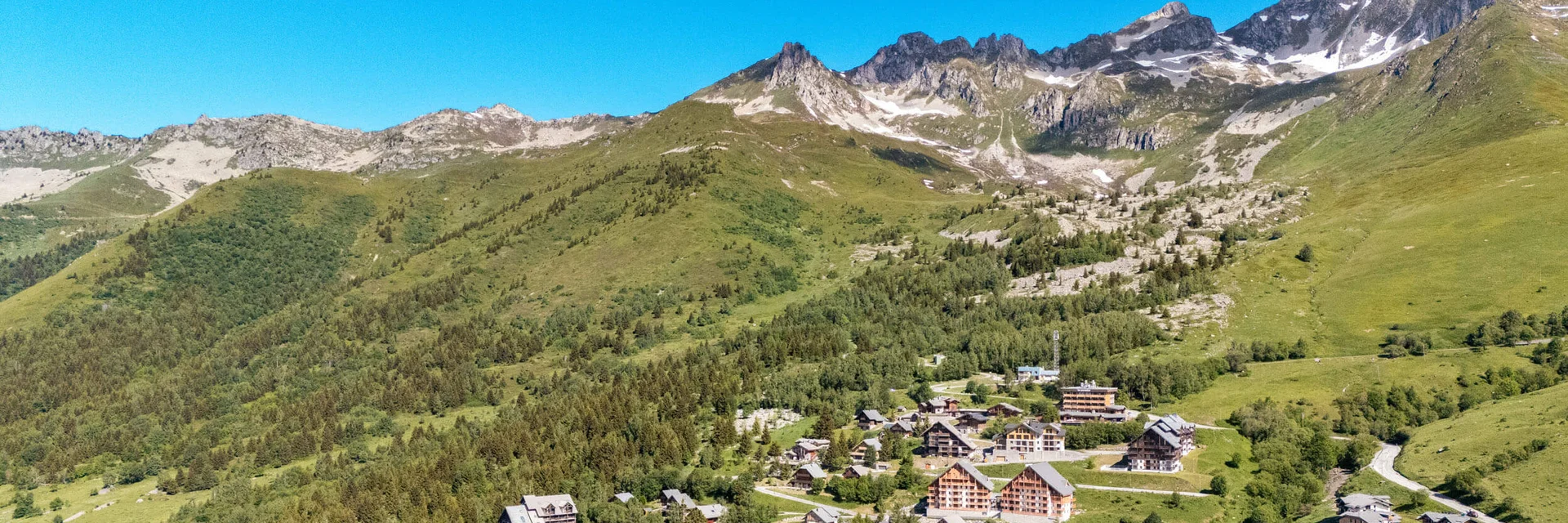 Maurienne Bergdorp met huizen en groene heuvels onder een blauwe lucht