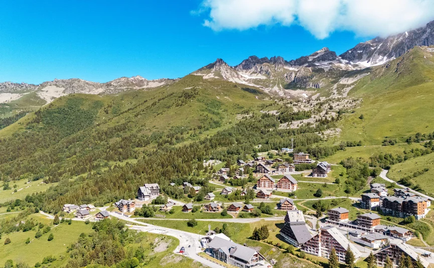 Motorvakantie in de Maurienne Bergdorp met huizen en groene heuvels onder een blauwe lucht