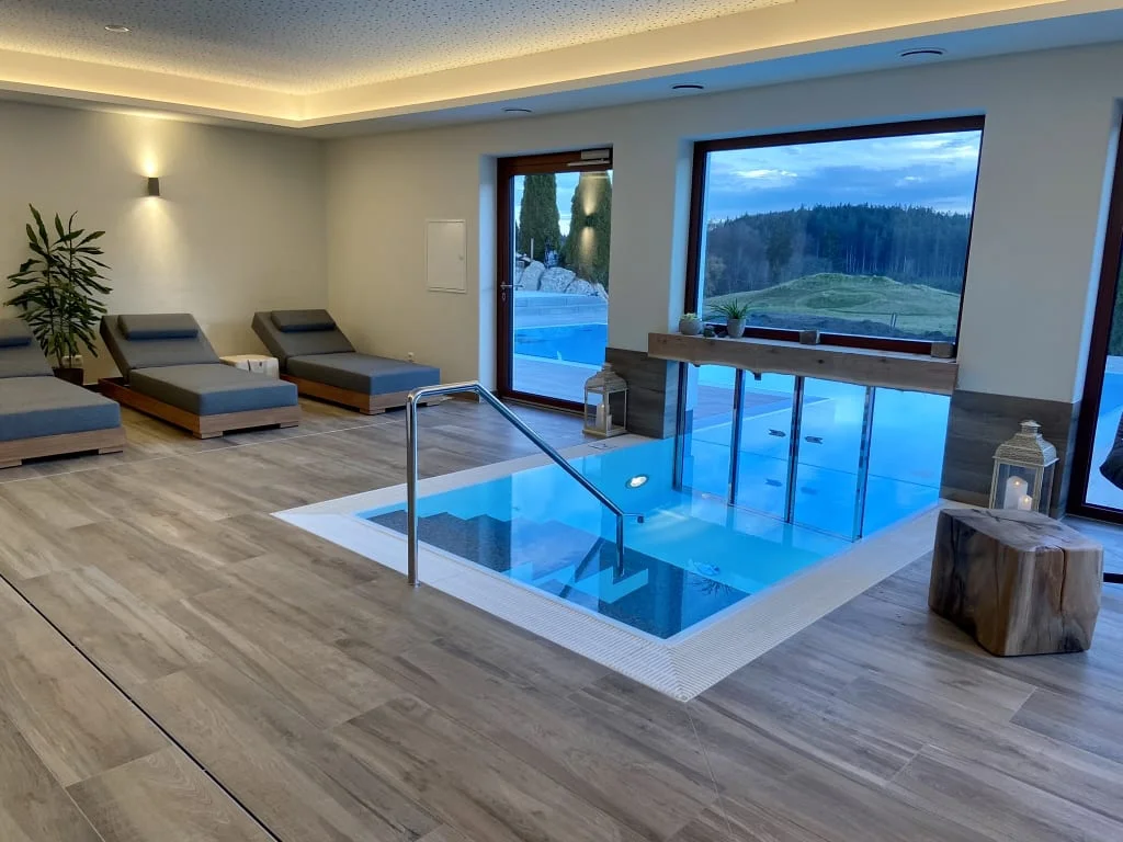 WELLNESS-TAGE am Wochenende Moderne wellnessruimte met bubbelbad, ligstoelen en uitzicht op groene heuvels