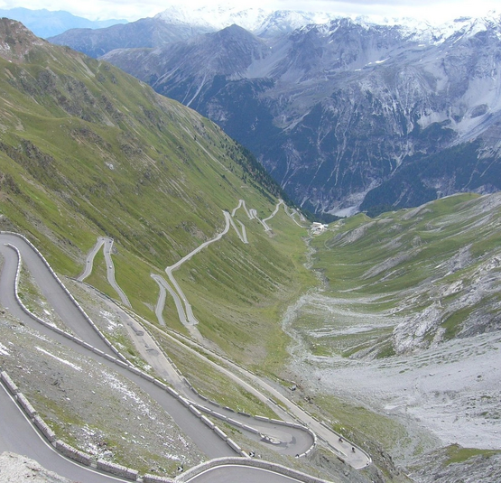 Serpentinenstraße in den Alpen mit Bergen und schneebedeckten Gipfeln