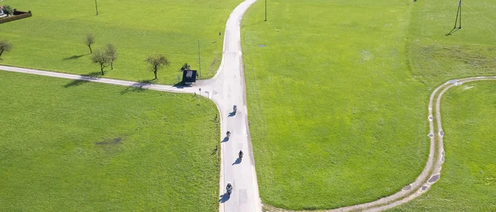 Savinja Vallei © Matic Šuc Luchtfoto van een lange landweg met fietsers door groene velden