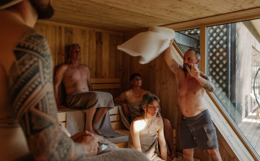 Sweaty Weekends Groep mensen ontspant in een houten sauna met groot raam
