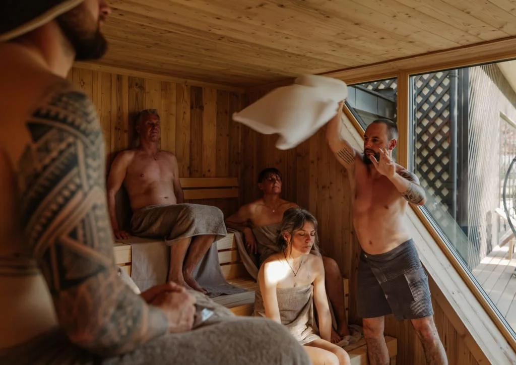Sweaty Weekends Groep mensen ontspant in een houten sauna met groot raam