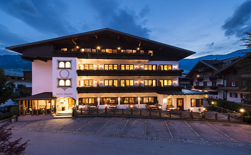 Beleuchtetes Hotelgebäude am Abend in den Bergen