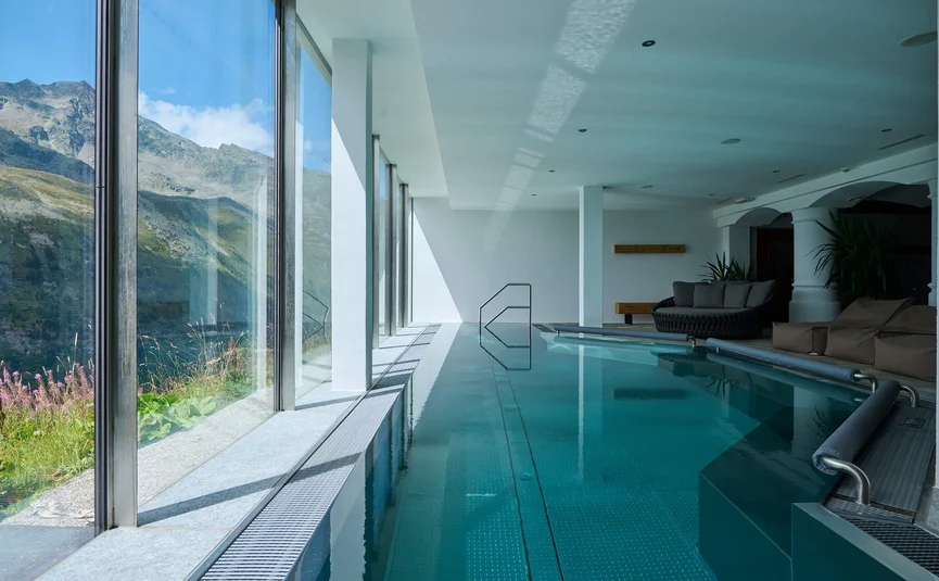 Indoor pool with large glass windows and mountain view