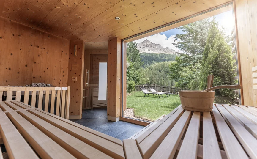 Wooden sauna interior with garden and mountain view