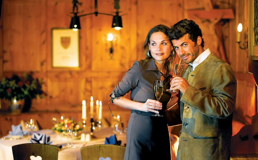 Couple toasting with champagne glasses in cozy candlelit restaurant