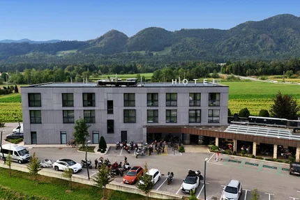 Hotel Grof © Hotel Grof Modernes Hotel mit Parkplatz vor grünen Feldern und bewaldeten Bergen