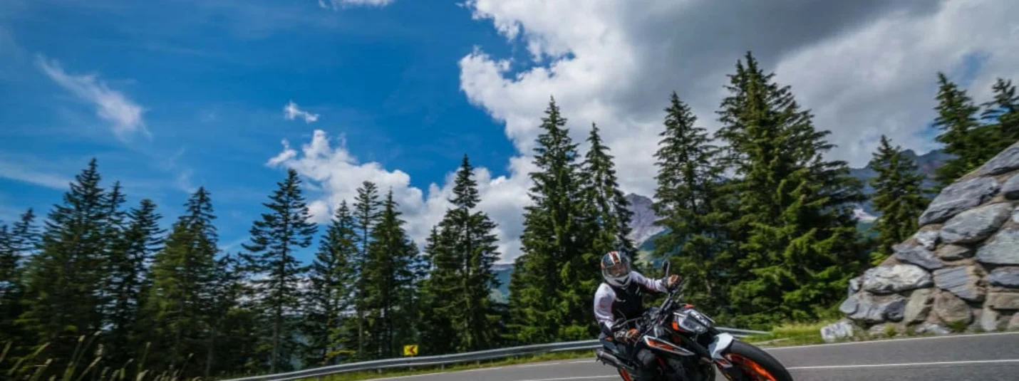 2 days motor bike fun Motorcyclist riding around a curve on mountain road under sunny sky