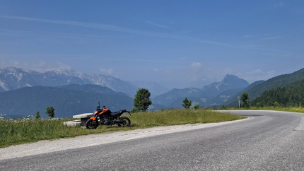 Postalmtour Motorrad geparkt neben einer Bank auf Bergstraße mit Alpenblick
