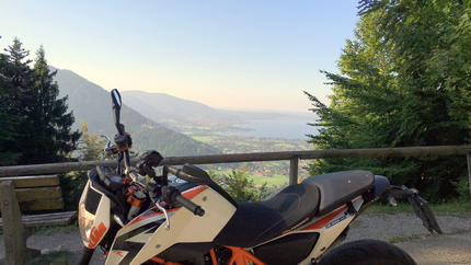 Motorrad vor Berglandschaft mit See und blauem Himmel