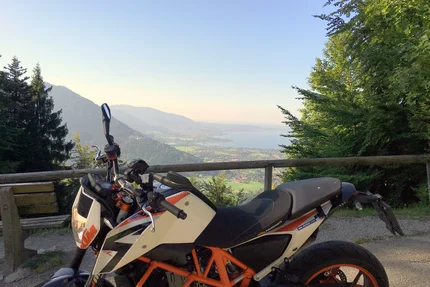 Motorcycle parked with mountain view and lake in background