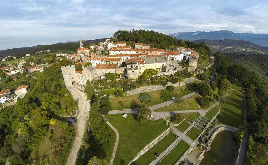 Luchtfoto van een historische vestingstad op een heuvel met omliggende bergen