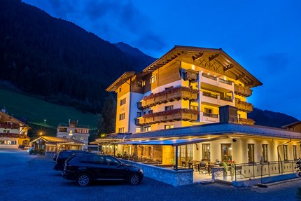 Hotel – Wirtshaus Lenz © Jones Art Beleuchtetes Hotel in den Bergen bei Nacht mit geparkten Autos