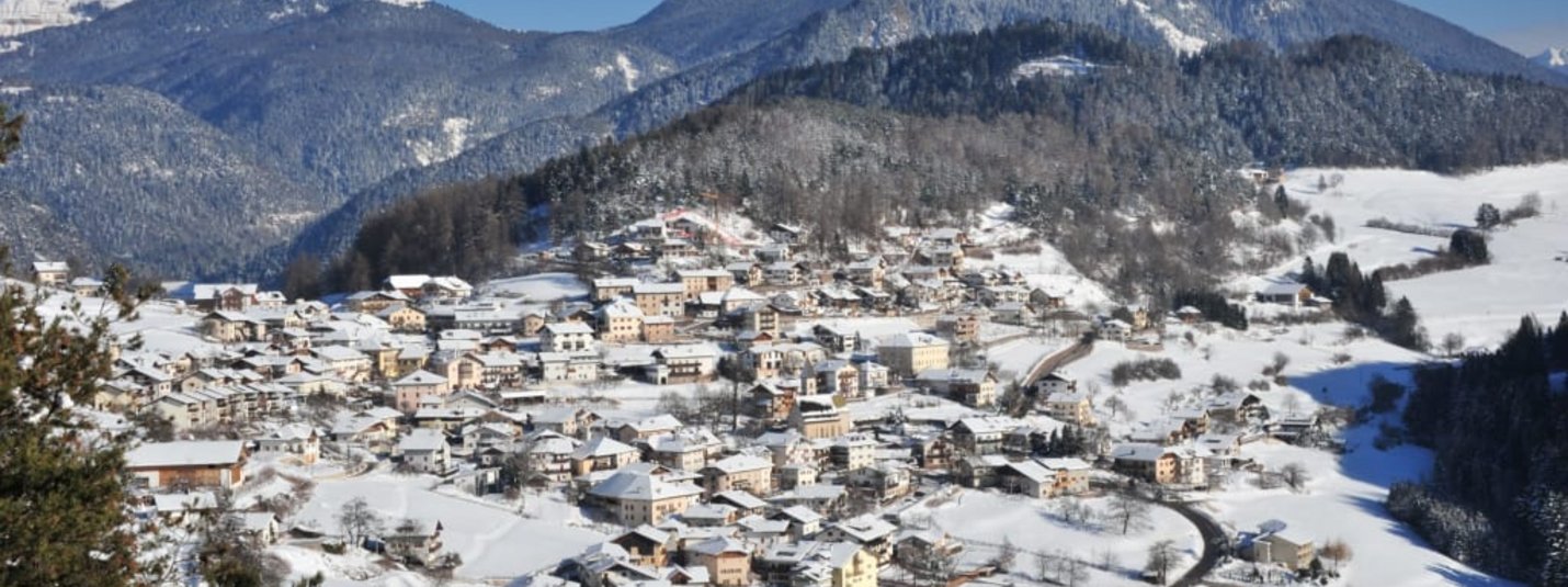 Winterträume, Wandern & Genuss 5=4 Schneebedecktes Dorf in einem Tal vor schneebedeckten Bergen