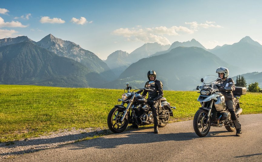 Motorradurlaub in Kärnten © Moppetfoto.de Zwei Motorradfahrer auf Landstraße mit grünen Wiesen und Alpen im Hintergrund