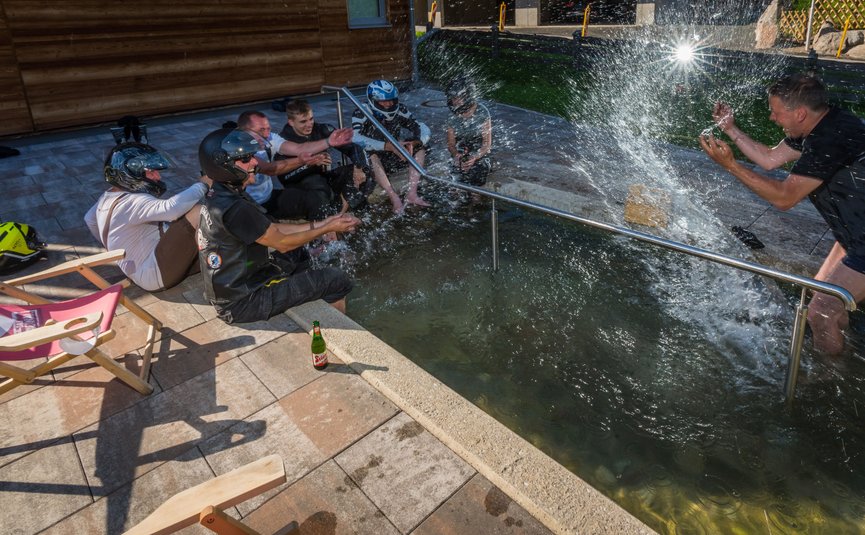 Gruppe von Menschen kühlt sich in einem Wasserbecken an einem sonnigen Tag ab