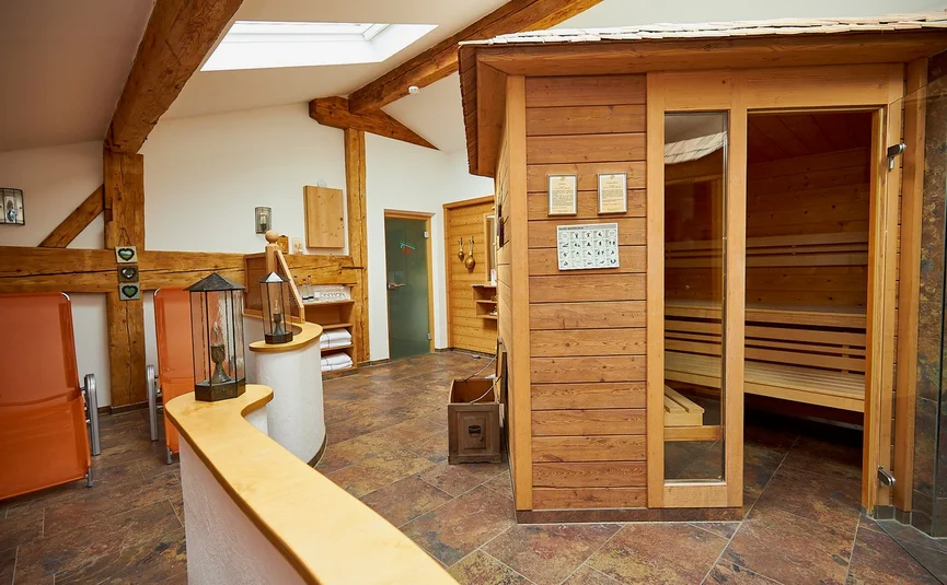 Interior view of a sauna room with wooden sauna and relaxing seating