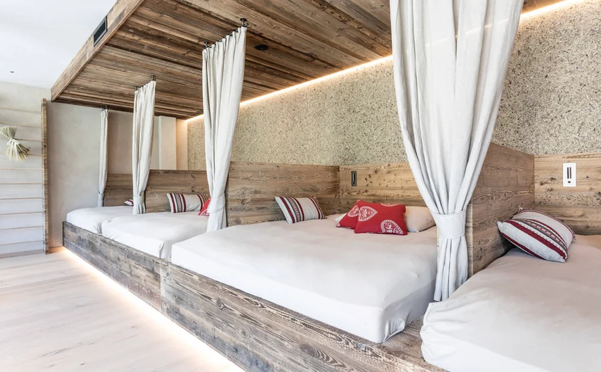 Motorrad- & Spa Hotel Traube Post am Reschensee **** © Theiner Karl-Heinz & Co KG Gemütliche Bettnischen mit Holzwand und rot-weißen Kissen