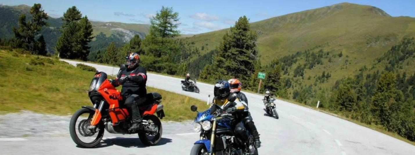 Motorrijders op kronkelende bergweg bij heldere lucht