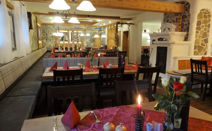 Cozy restaurant interior with candlelit tables and red napkins