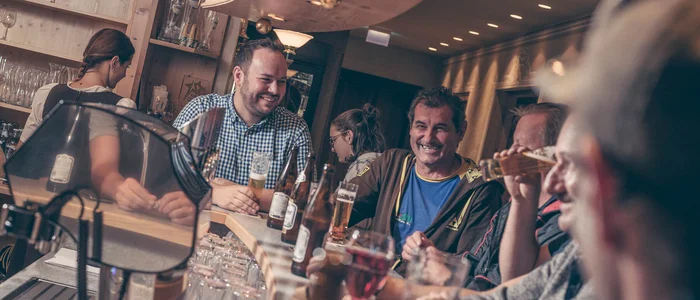 People laughing and drinking together at a bar