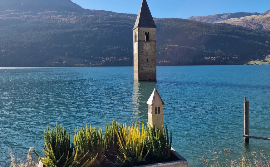 Submerged church tower in lake with planter decoration in foreground