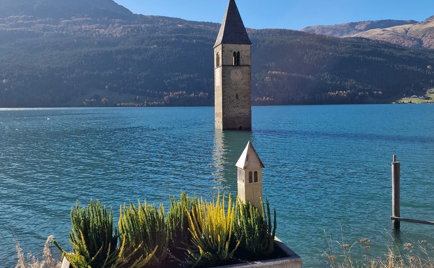 MoHo Schönauer Hof- Tour 12 Stilfserjoch Umbrail Submerged church tower in lake with planter decoration in foreground