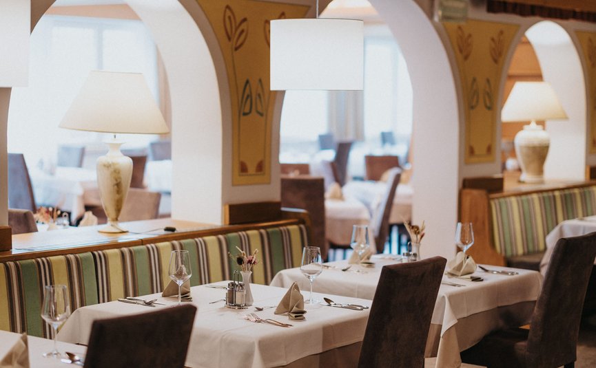 Elegantes Restaurant mit gedeckten Tischen und gemütlicher Atmosphäre