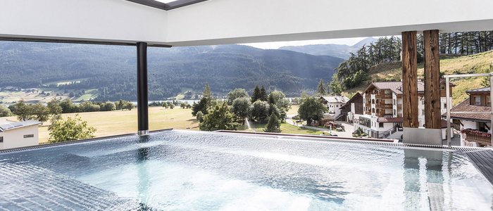 Motorrad- & Spa Hotel Traube Post am Reschensee **** © Theiner Karl-Heinz & Co KG Moderner Pool mit Blick auf Alpen und Dorf im Tal