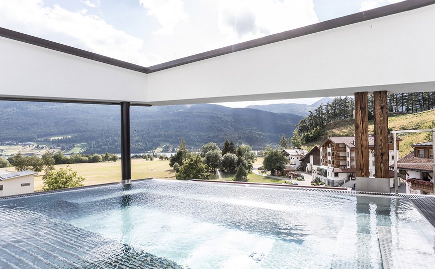 Motorrad- & Spa Hotel Traube Post am Reschensee **** © Theiner Karl-Heinz & Co KG Moderner Pool mit Blick auf Alpen und Dorf im Tal