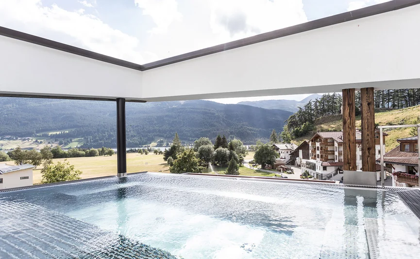 Motorrad- & Spa Hotel Traube Post am Reschensee **** © Theiner Karl-Heinz & Co KG Moderner Pool mit Blick auf Alpen und Dorf im Tal
