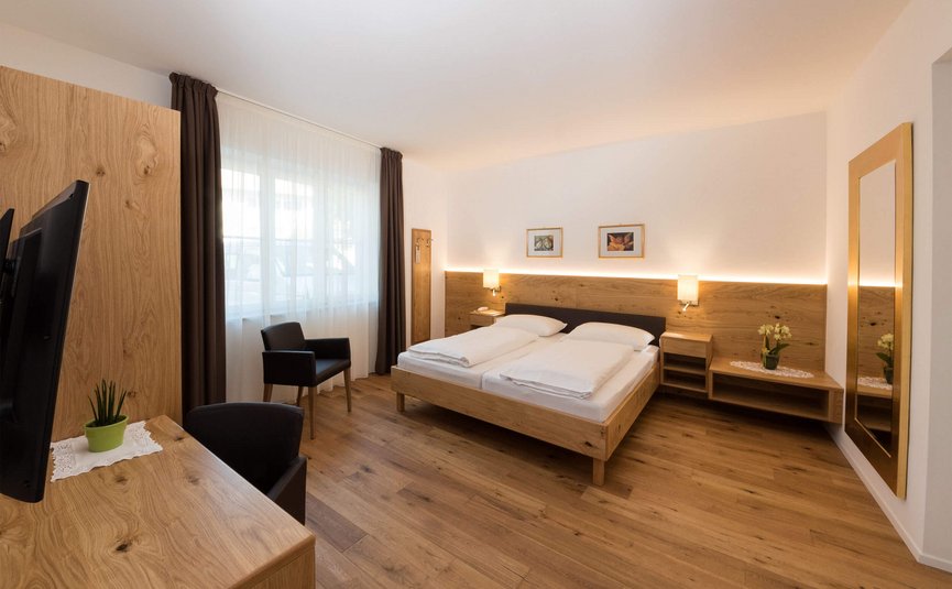 Modernes Hotelzimmer mit Holzmöbeln und Doppelbett