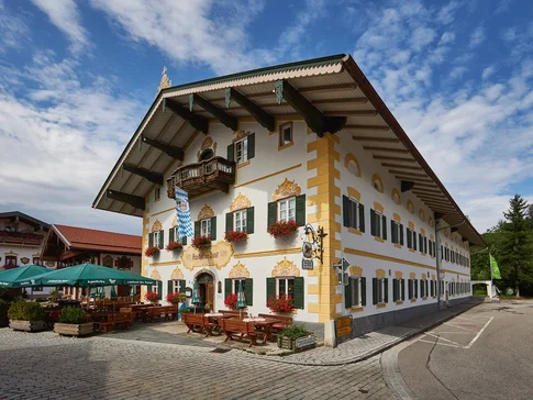 Traditionelles bayerisches Gasthaus mit Außenbestuhlung und Blumendekor