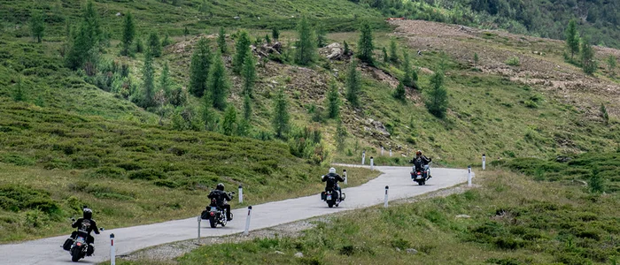 East Tyrol - Grossglockner - Lienz Dolomites © Armin Kleinlercher Four motorcycles riding on mountain road with fog and green hills