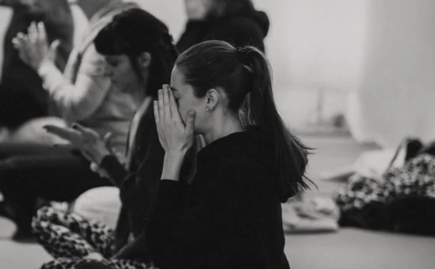 Gruppe von Menschen in Madsitz auf Matten in einer Meditations- oder Yogaklasse