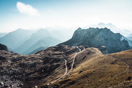 The Ultimate Julian Alps Ride Schmale Straßen durch felsige Berge unter klarem Himmel