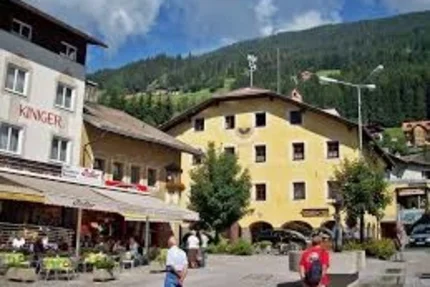 Busy square with people, restaurants and mountains in the background