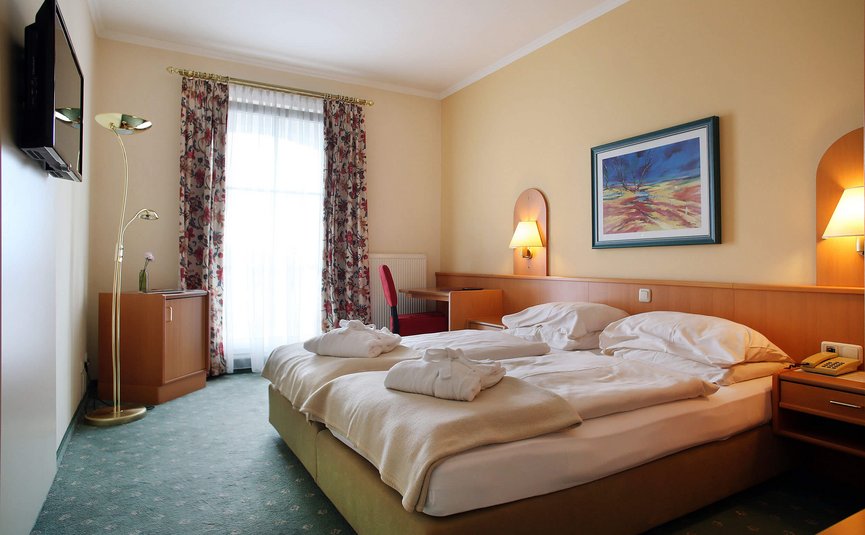 Gemütliches Hotelzimmer mit Doppelbett, TV und Schreibtisch