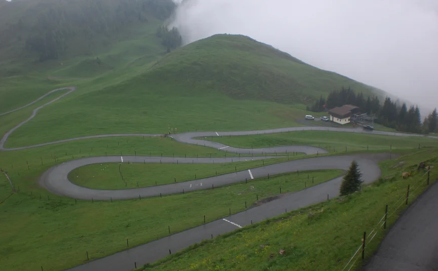 7 Hotel Sonnleiten: Gerlospass, Thurnpas, Kitzbühlerhorn Kronkelende bergweg op groene heuvels met mistig weer
