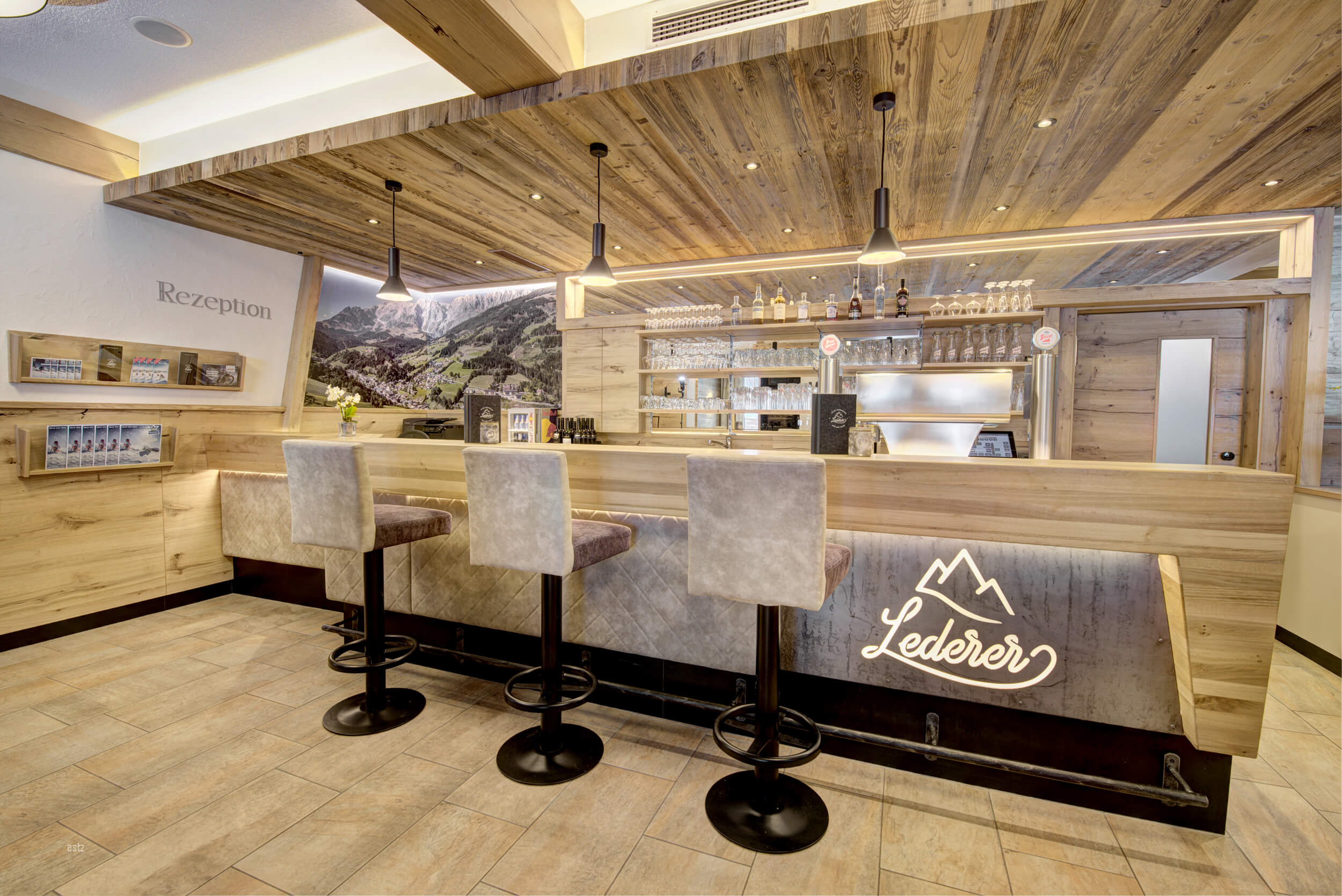 Modern hotel reception area with bar and high stools