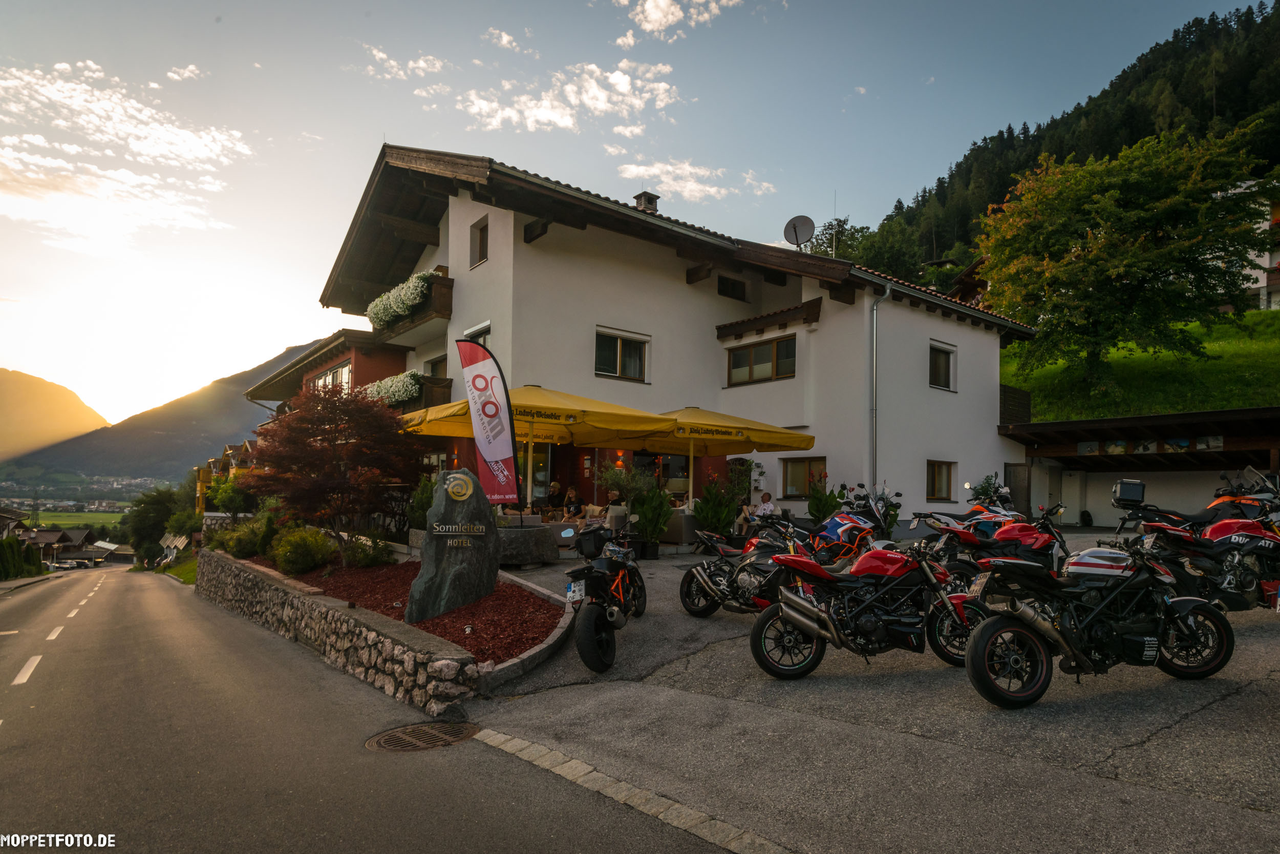 Hotel with motorcycles parked at sunset in the mountains