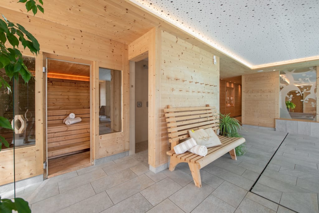 Hell beleuchteter Saunabereich mit Holzbänken und Handtüchern