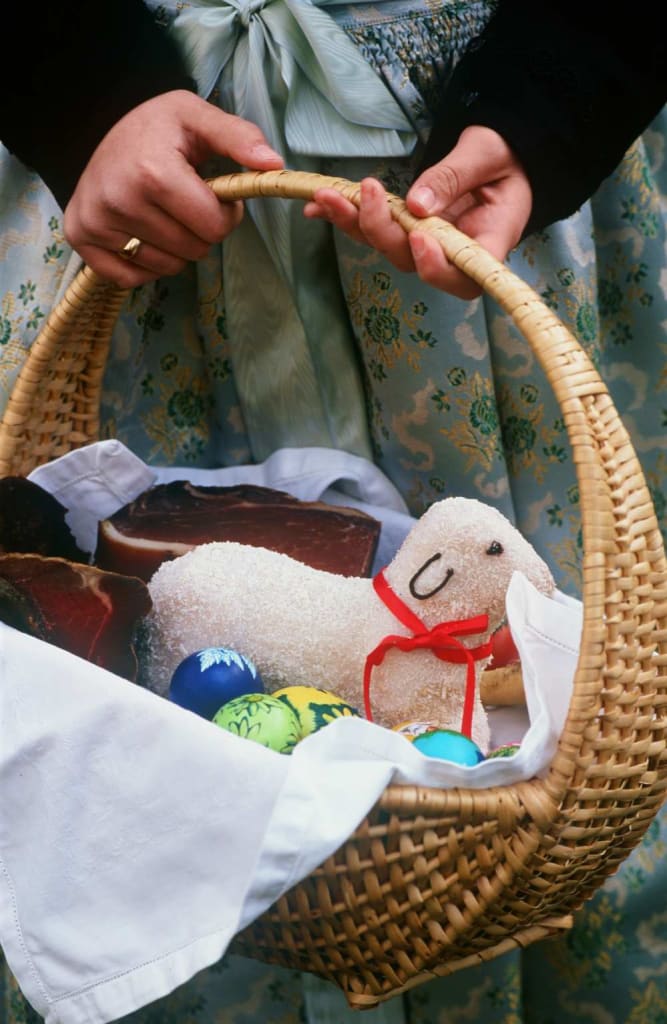 Osterkorb mit bunten Eiern, Osterlamm und Schinken
