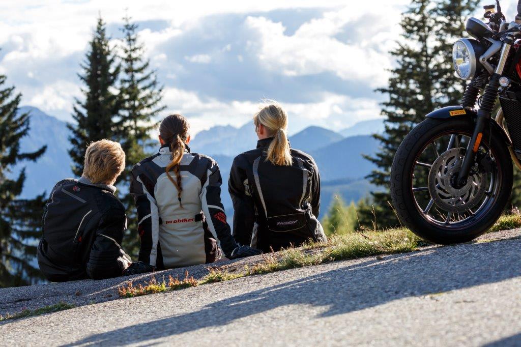 4/5 Nächte - Frühlings-Motorrad-Spass in Val di Sole Drei Motorradfahrer sitzen auf einer Anhöhe mit Bergpanorama im Hintergrund