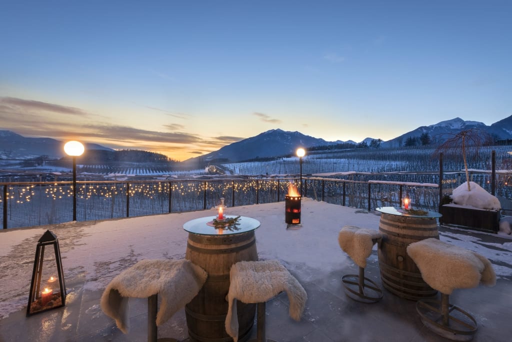 Winterterrasse mit Sitzgelegenheiten und Bergblick bei Sonnenuntergang
