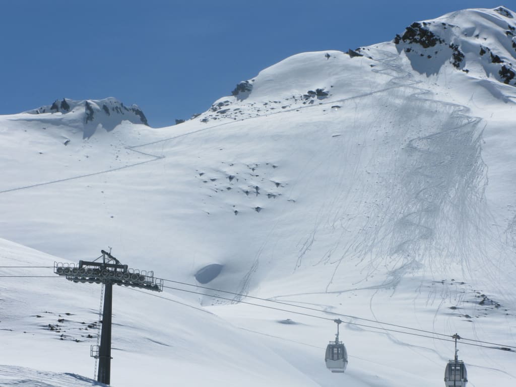Schneebedeckter Berg mit Skilift und Ski-Spuren im Schnee